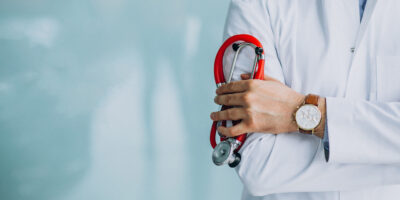 Young handsome physician in a medical robe with stethoscope